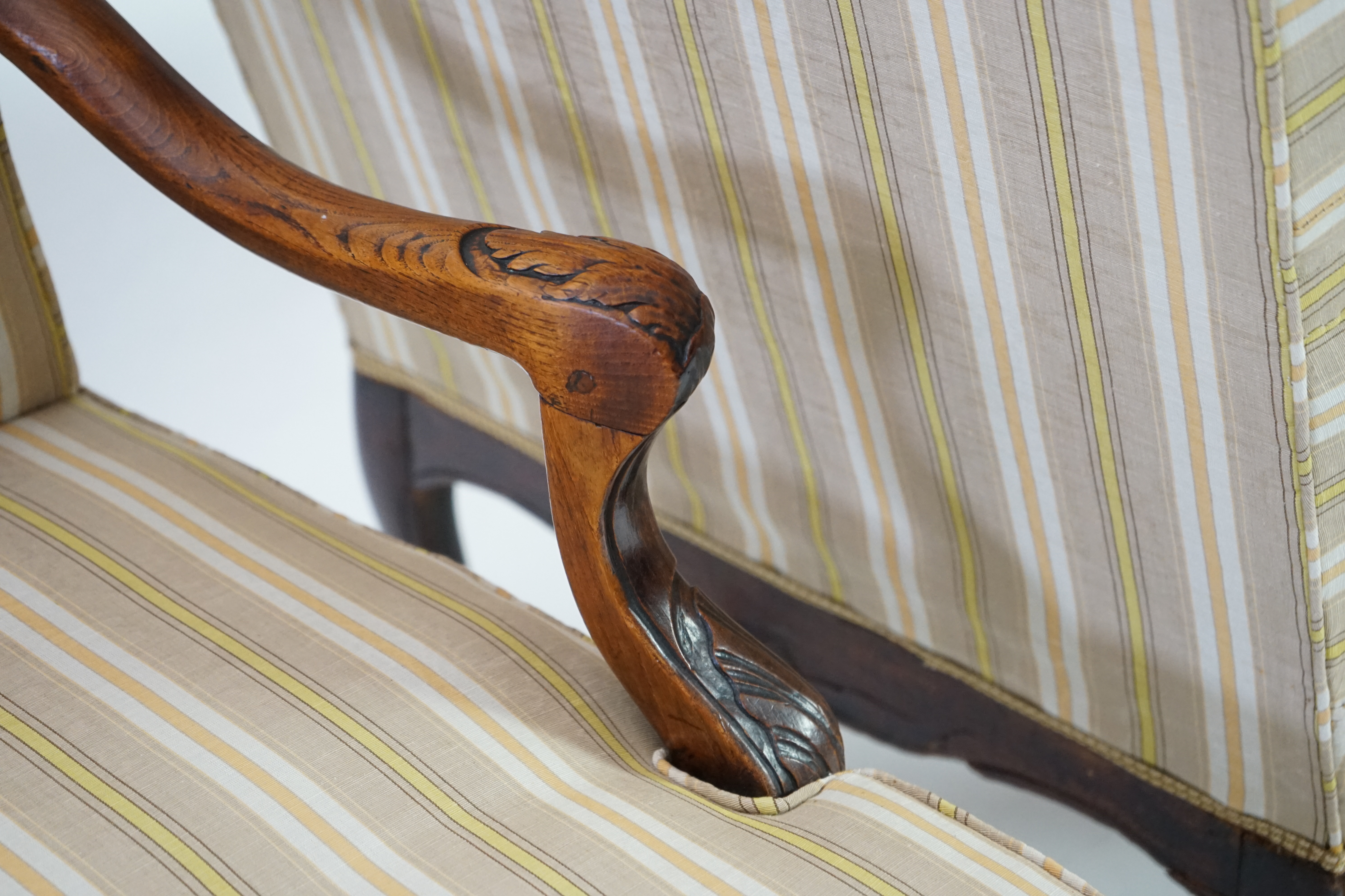 A pair of Louis XVI walnut fauteuils with upholstered backs and seats and foliate carved arms and underframes, on cabriole legs, width 67cm, depth 76cm, height 104cm. Condition - fair